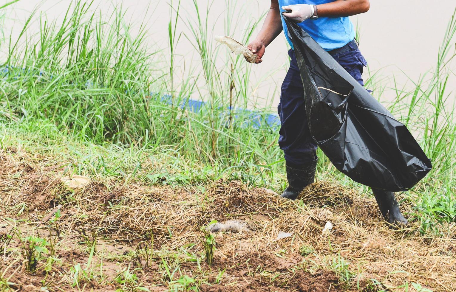 Man volunteers helping to keep nature clean and picking up the garbage from park - Recycling and waste reduction techniques that help the environment photo