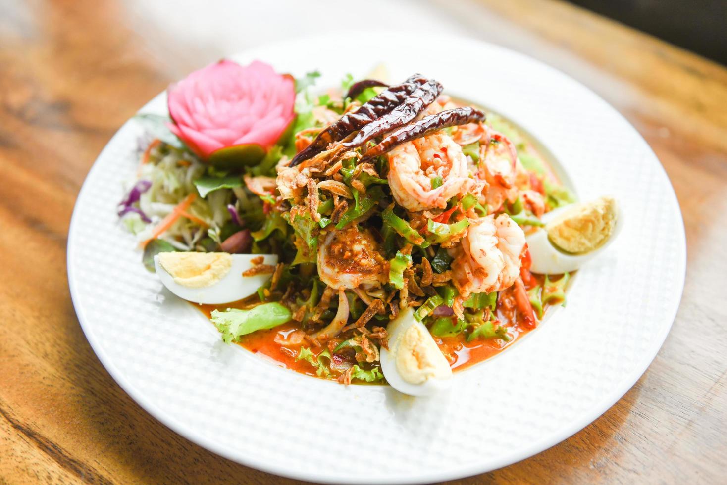 Wing bean shrimp salad spicy with boiled eggs on white plate - shrimp prawn seafood salad Thai food photo