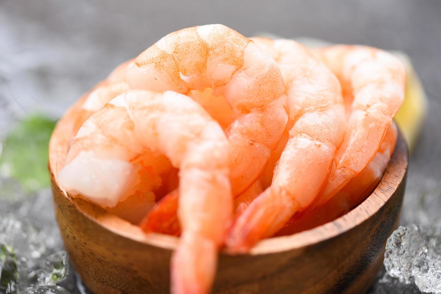 camarones hervidos langostinos en hielo congelado en el restaurante de mariscos camarones frescos en un tazón de madera con ingredientes para cocinar mariscos foto