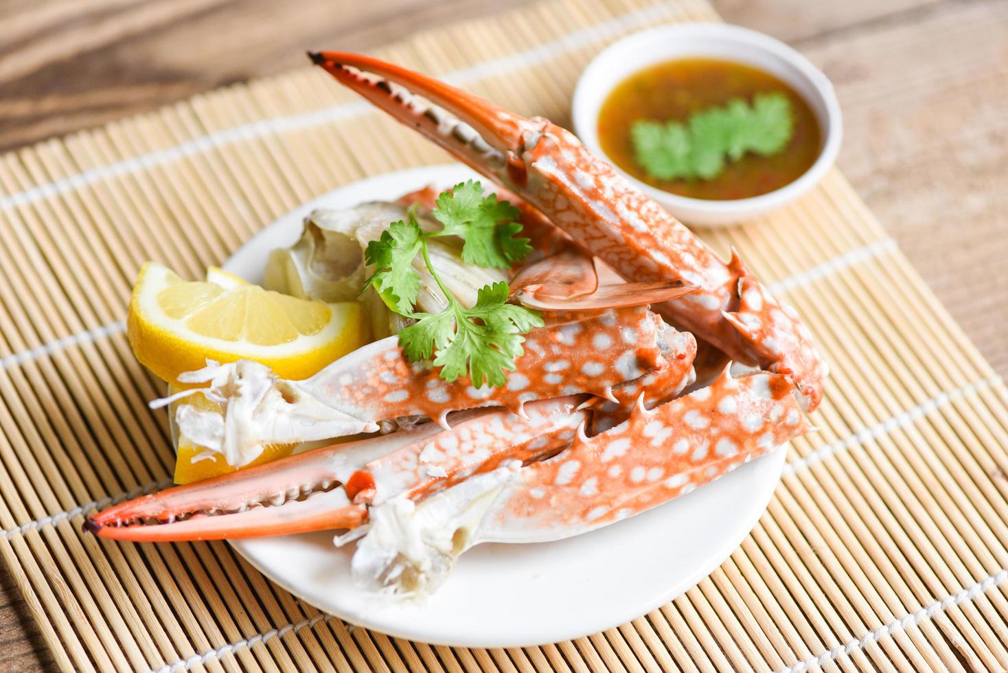 Boiled crab food on white plate and seafood sauce on the table - crab claws shellfish photo