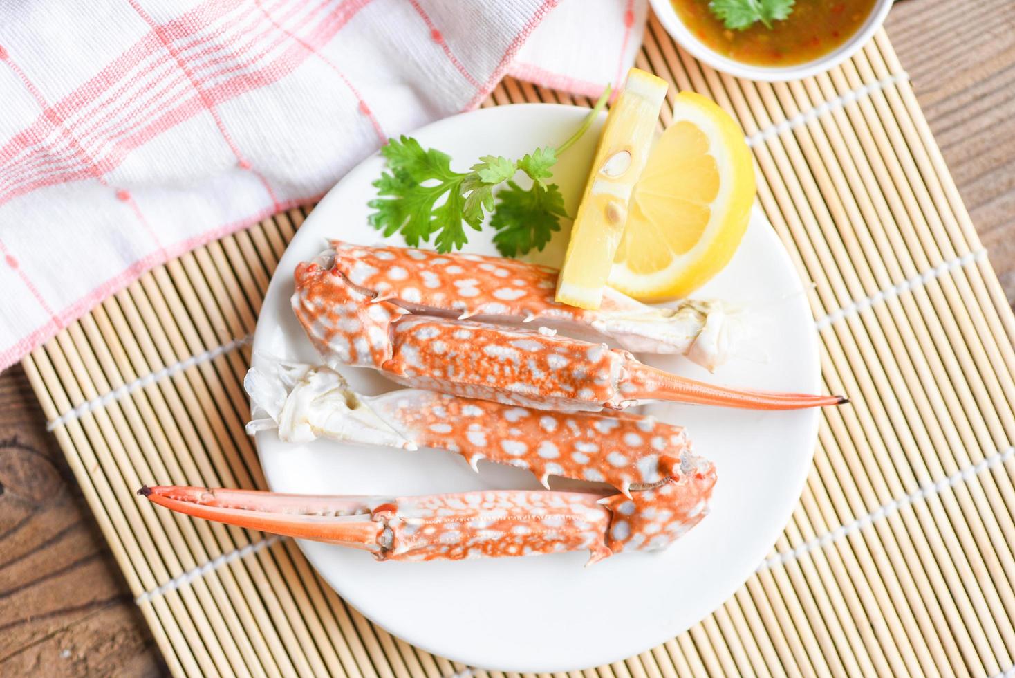 Boiled crab food on white plate and seafood sauce on the table - crab claws shellfish photo