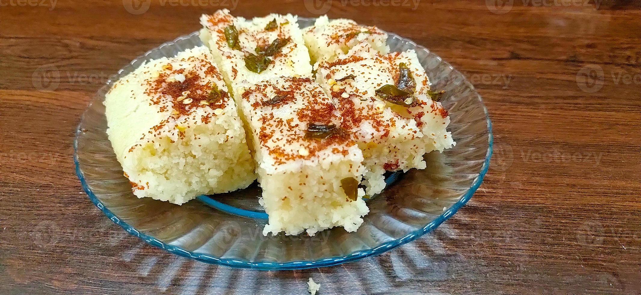 gujarati indio tradicional comida callejera khaman dhokla bocadillo hecho de harina de garbanzos y rava servido con sev y chile foto