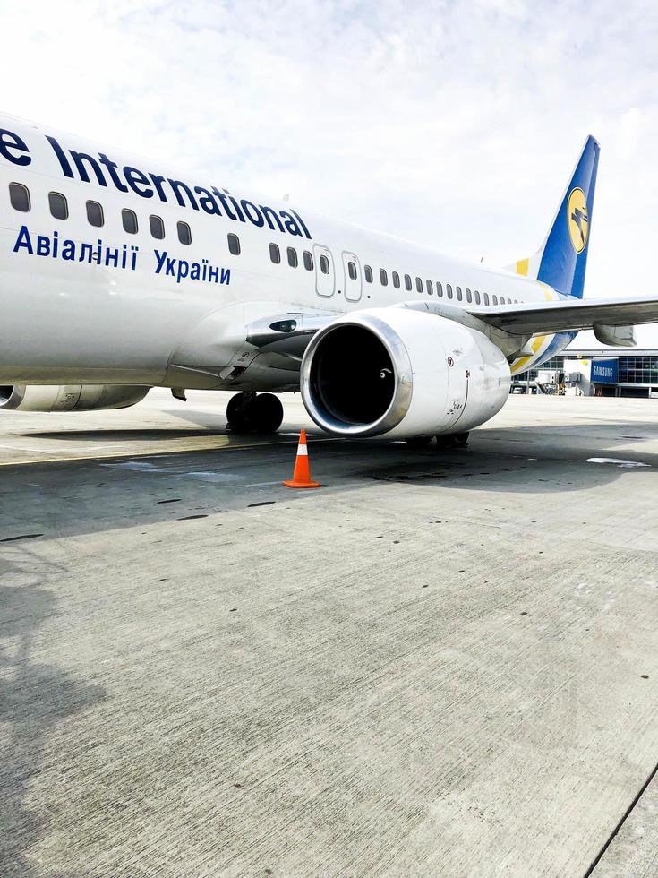 Beautiful fast white jet plane of Ukraine airlines with engine and wings on the runway at the airport. Ukraine, Kiev, April 17, 2019 photo