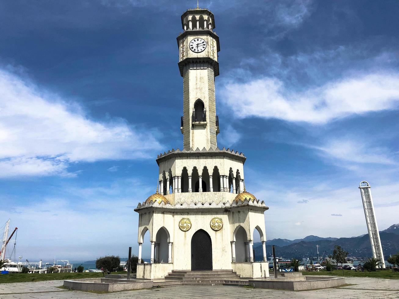 Large white classic lighthouse high in the port against the blue sky photo