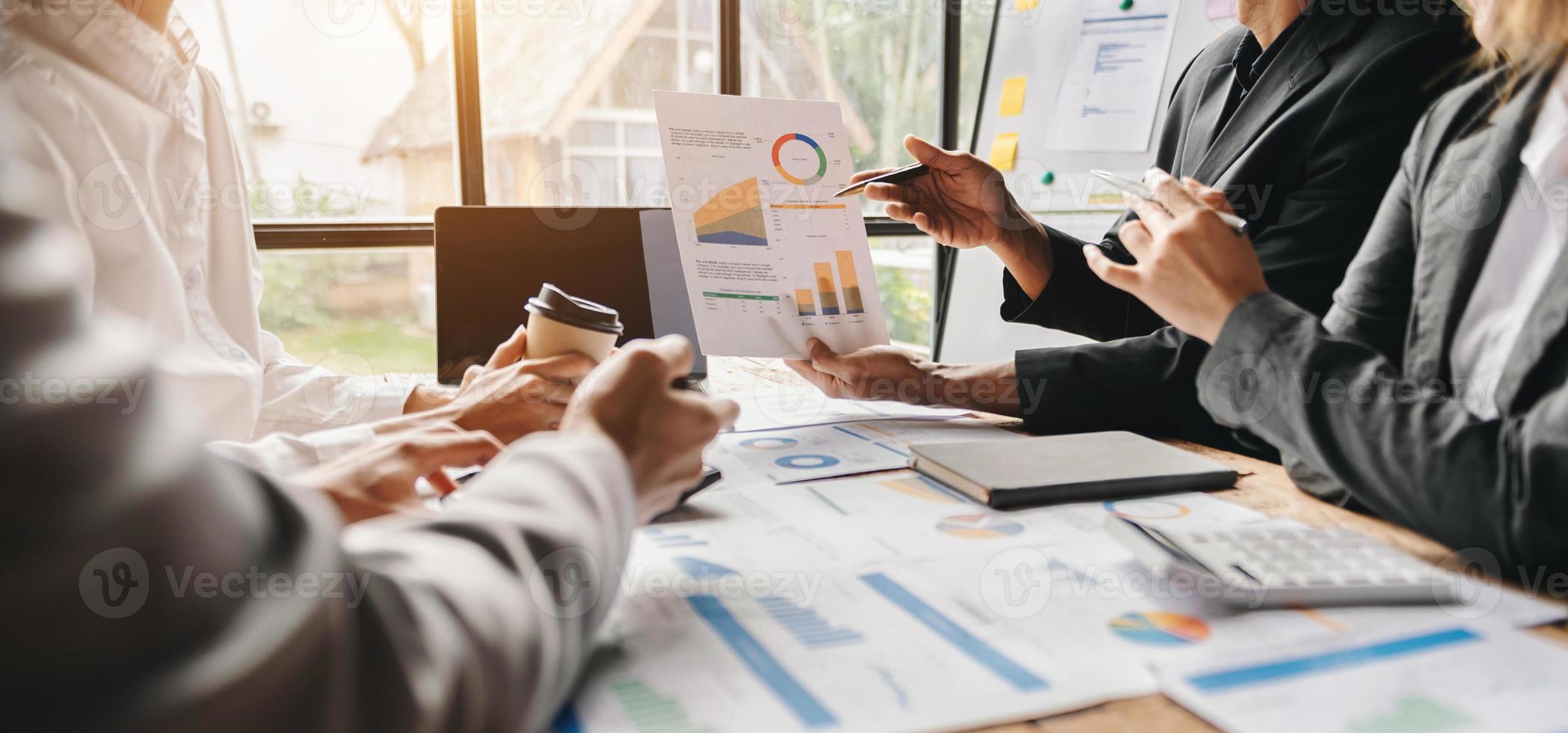 Business documents on office table with smart phone and calculator digital tablet and graph business with social network diagram and two colleagues discussing data working in the office photo