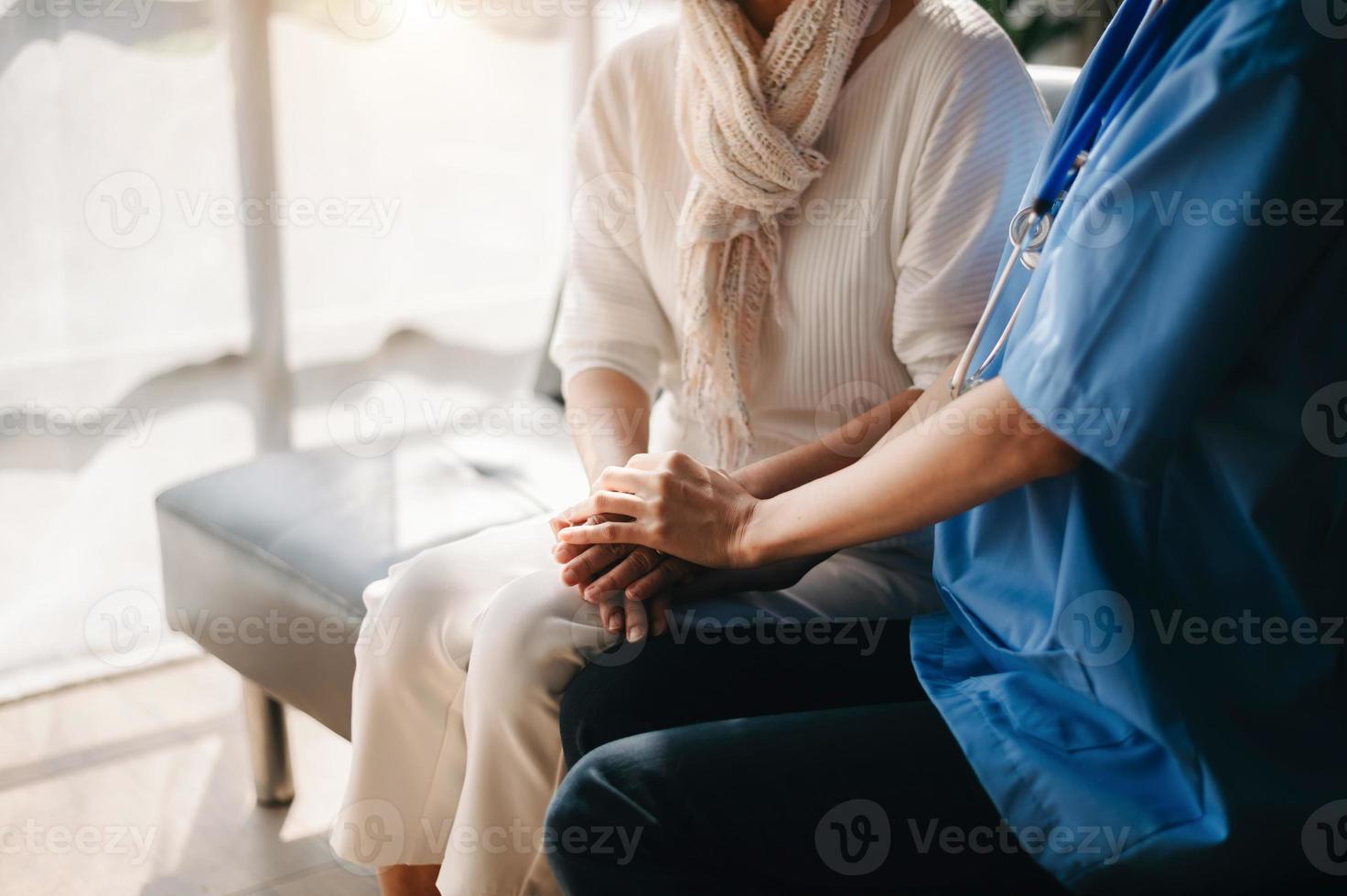 Close up view of old woman leaning on nurse while siting photo