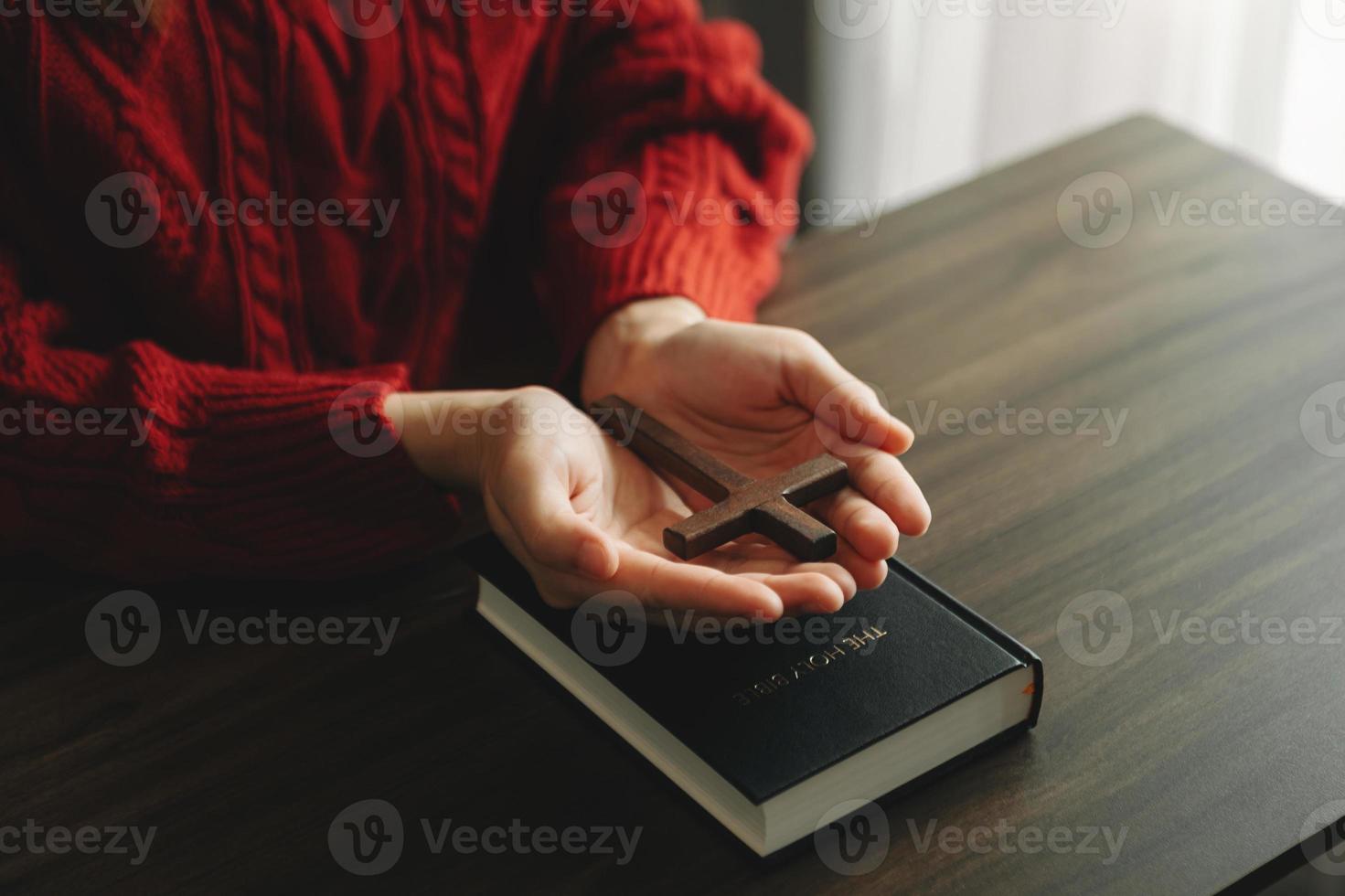 mujer sentada y estudiando las escrituras. la cruz de madera en las manos. conceptos de educación cristiana las sagradas escrituras abiertas foto