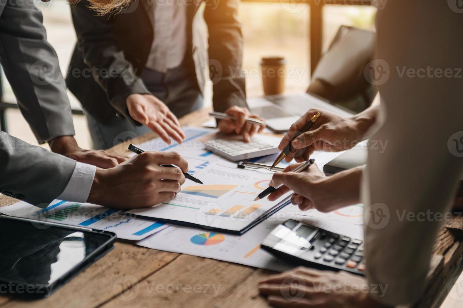 Business documents on office table with smart phone and calculator digital tablet and graph business with social network diagram and two colleagues discussing data working in the office photo