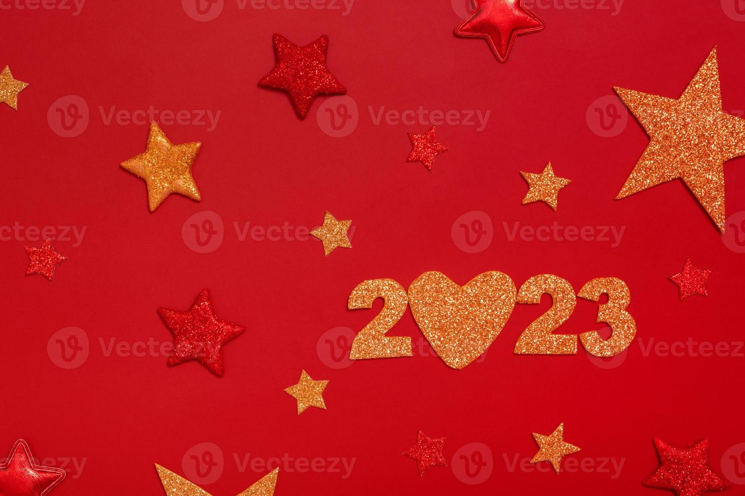 2023 new year flat lay concept. Numbers 2023 with red and gold stars, top view on red background photo