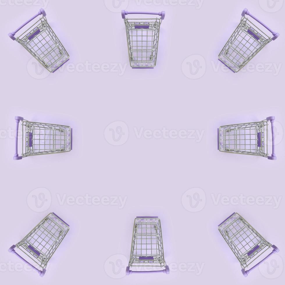 Pattern of many small shopping carts on a violet background. Minimalism flat lay top view photo