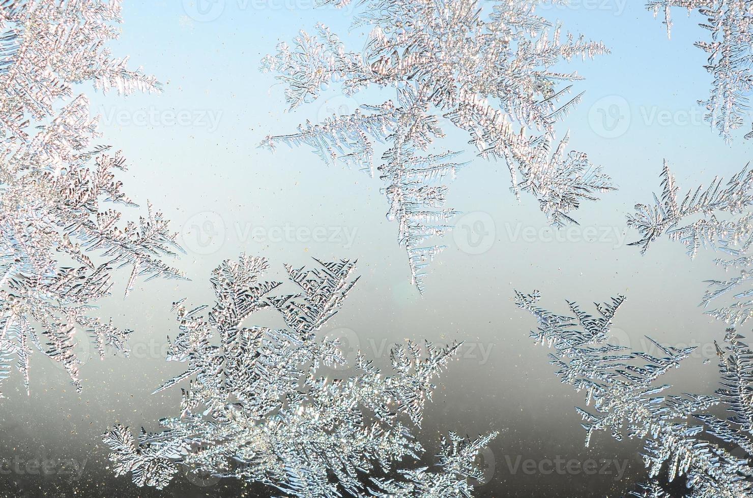 Snowflakes frost rime macro on window glass pane photo