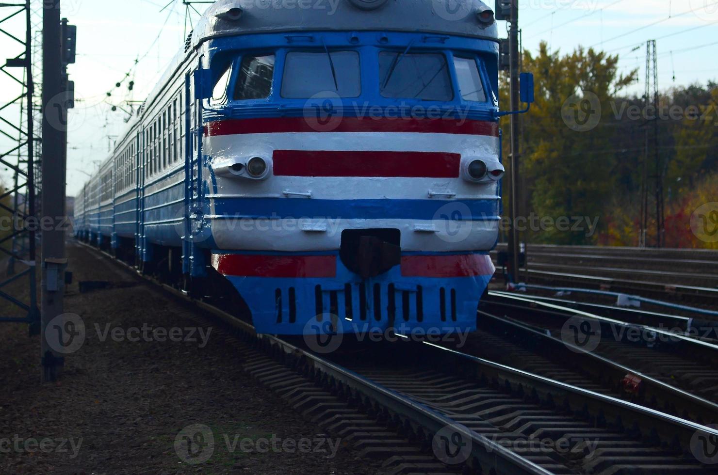 Old soviet electric train with outdated design moving by rail photo