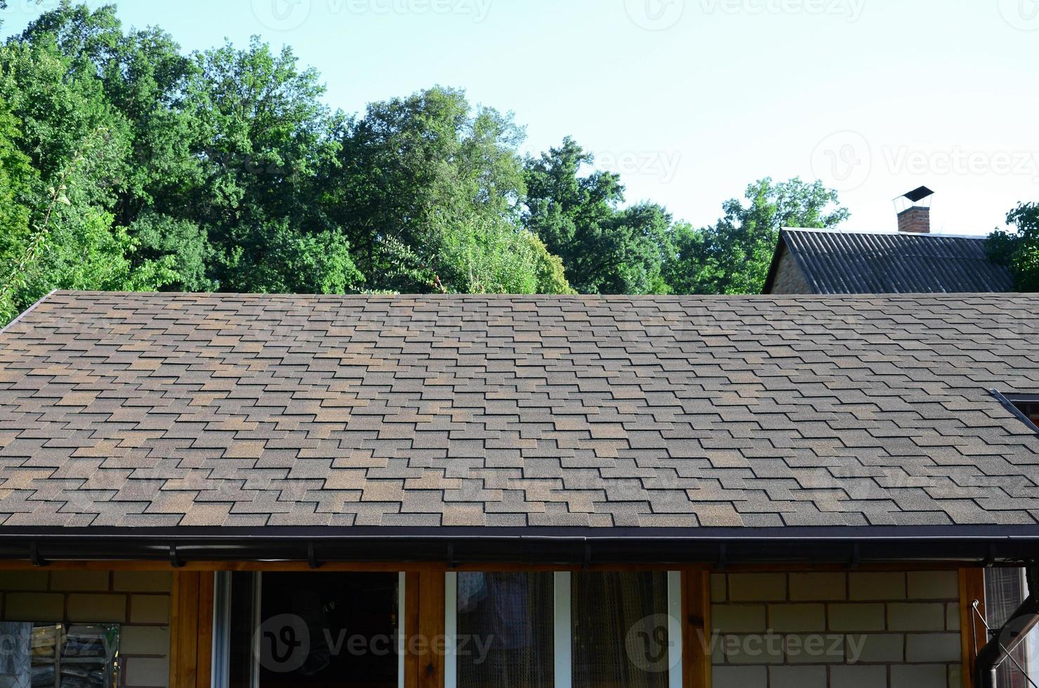 Modern roofing and decoration of chimneys. Flexible bitumen or slate shingles photo