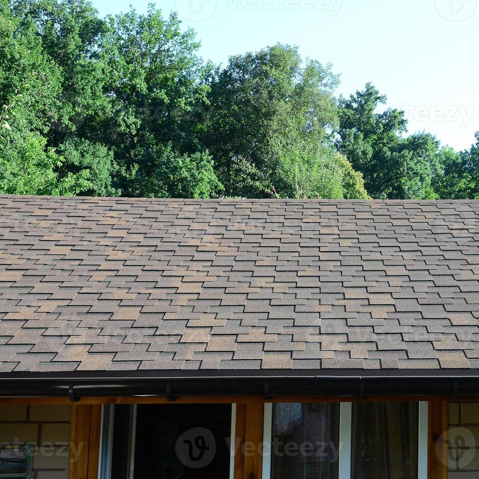 Modern roofing and decoration of chimneys. Flexible bitumen or slate shingles photo