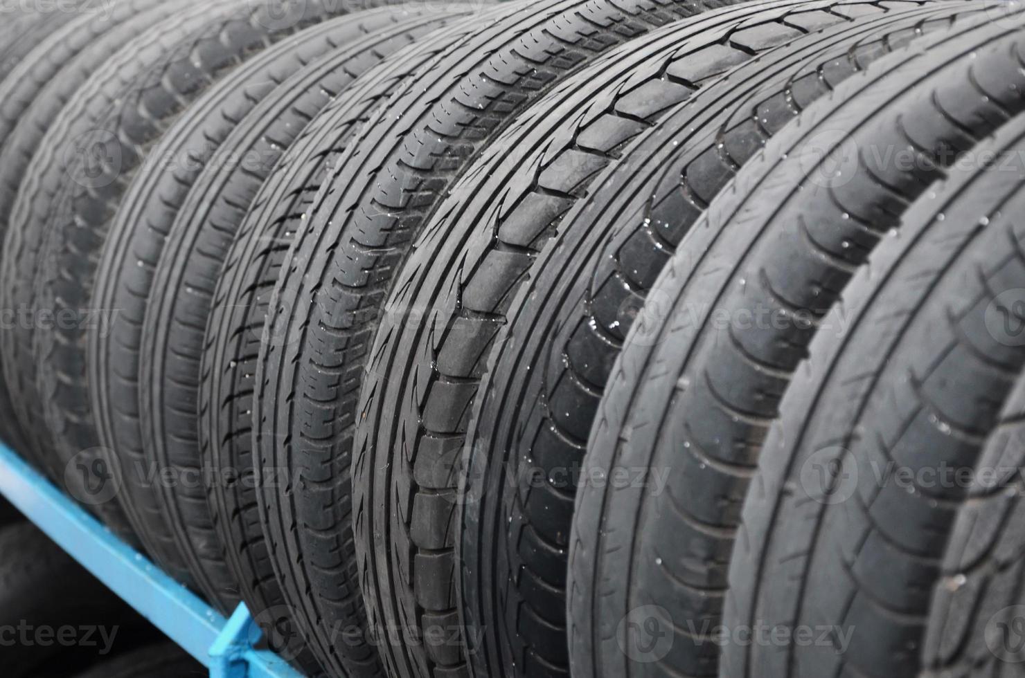 Rack with variety of car tires in automobile store. Many black tires. Tire stack background photo