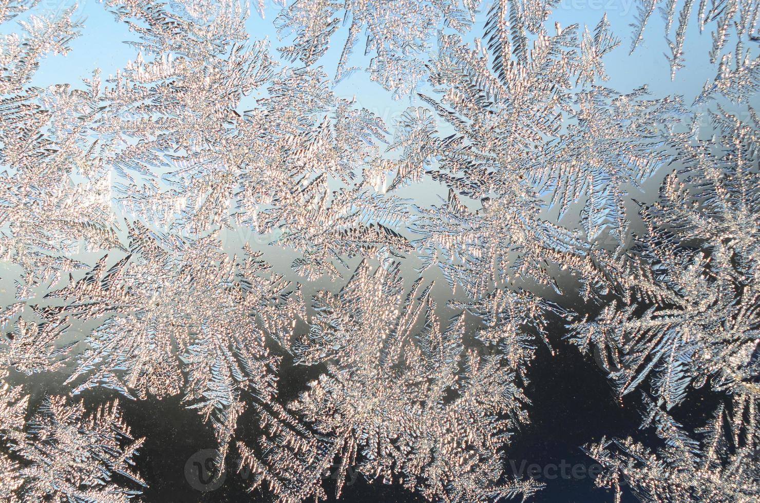 Snowflakes frost rime macro on window glass pane photo