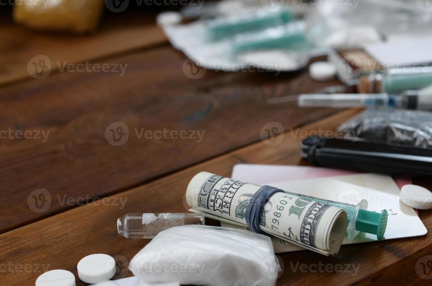 A lot of narcotic substances and devices for the preparation of drugs lie on an old wooden table photo