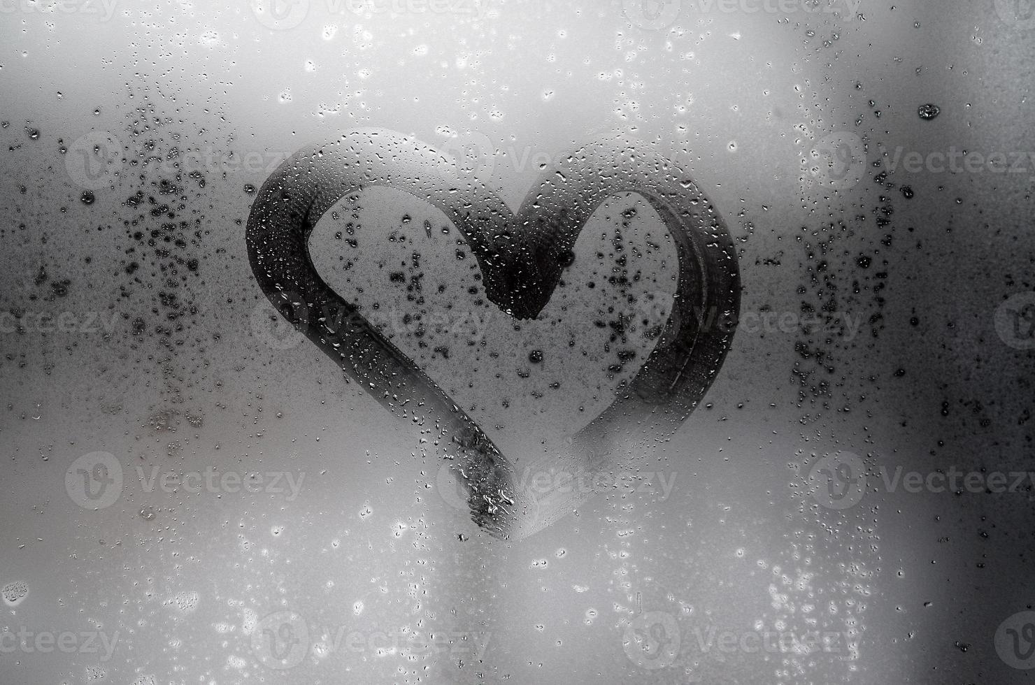 The heart is painted on the misted glass in winter photo