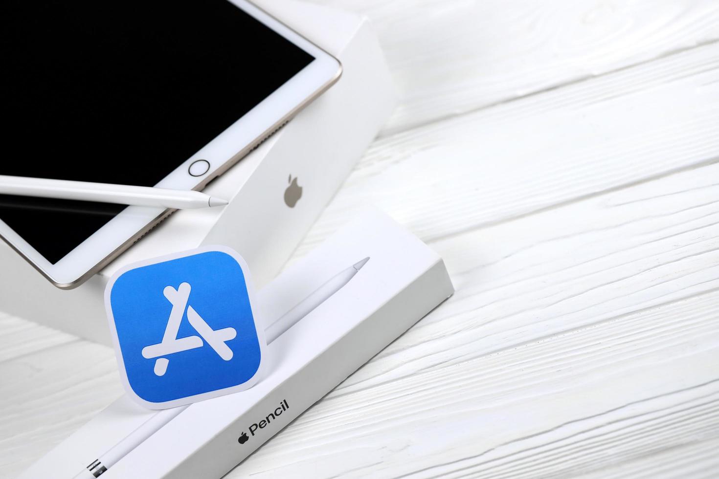 KHARKIV, UKRAINE - JANUARY 27, 2022 Brand new Apple iPad and Apple Pencil and blue app store logo on white background. Apple Inc. is an American technology company photo