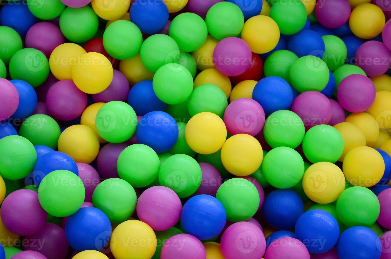 Swimming pool for fun and jumping in colored plastic balls photo