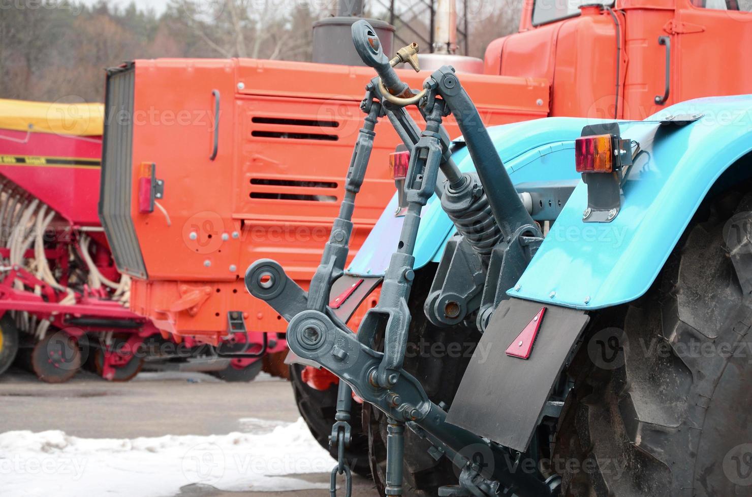 Wheels of back view of new tractor in snowy weather. Agricultural vehicle back photo