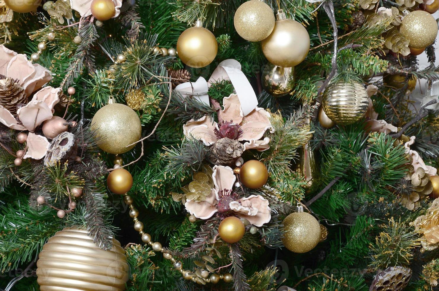 Decorating Christmas tree close up. Decoration bulb, green fir tree, golden x-mas toys and lights. Use for Christmas and New years celebration background photo