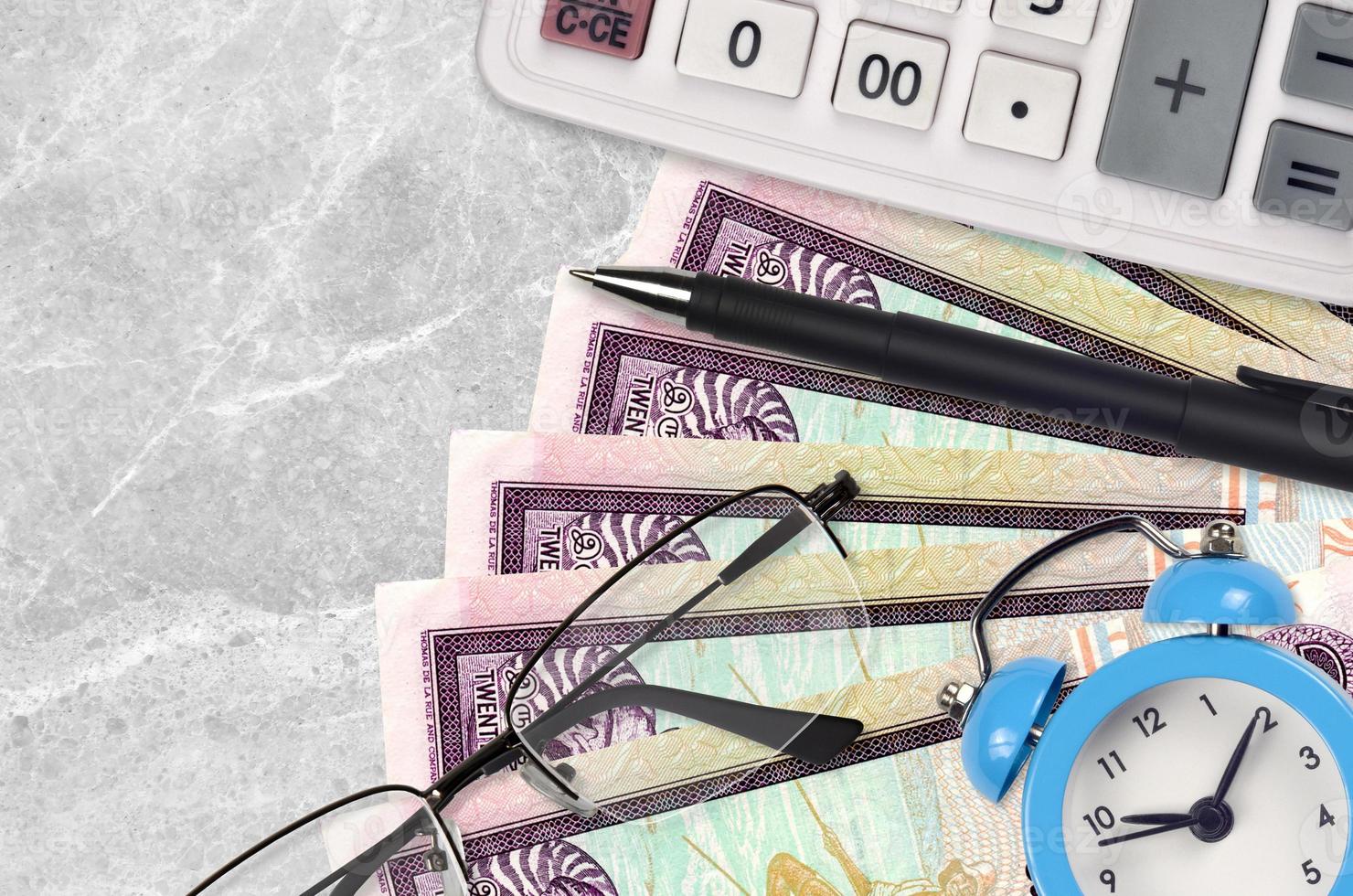 20 Sri Lankan rupees bills and calculator with glasses and pen. Business loan or tax payment season concept. Time to pay taxes photo