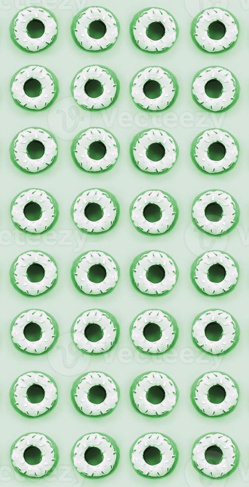Many small plastic donuts lies on a pastel colorful background. Flat lay minimal pattern. Top view photo