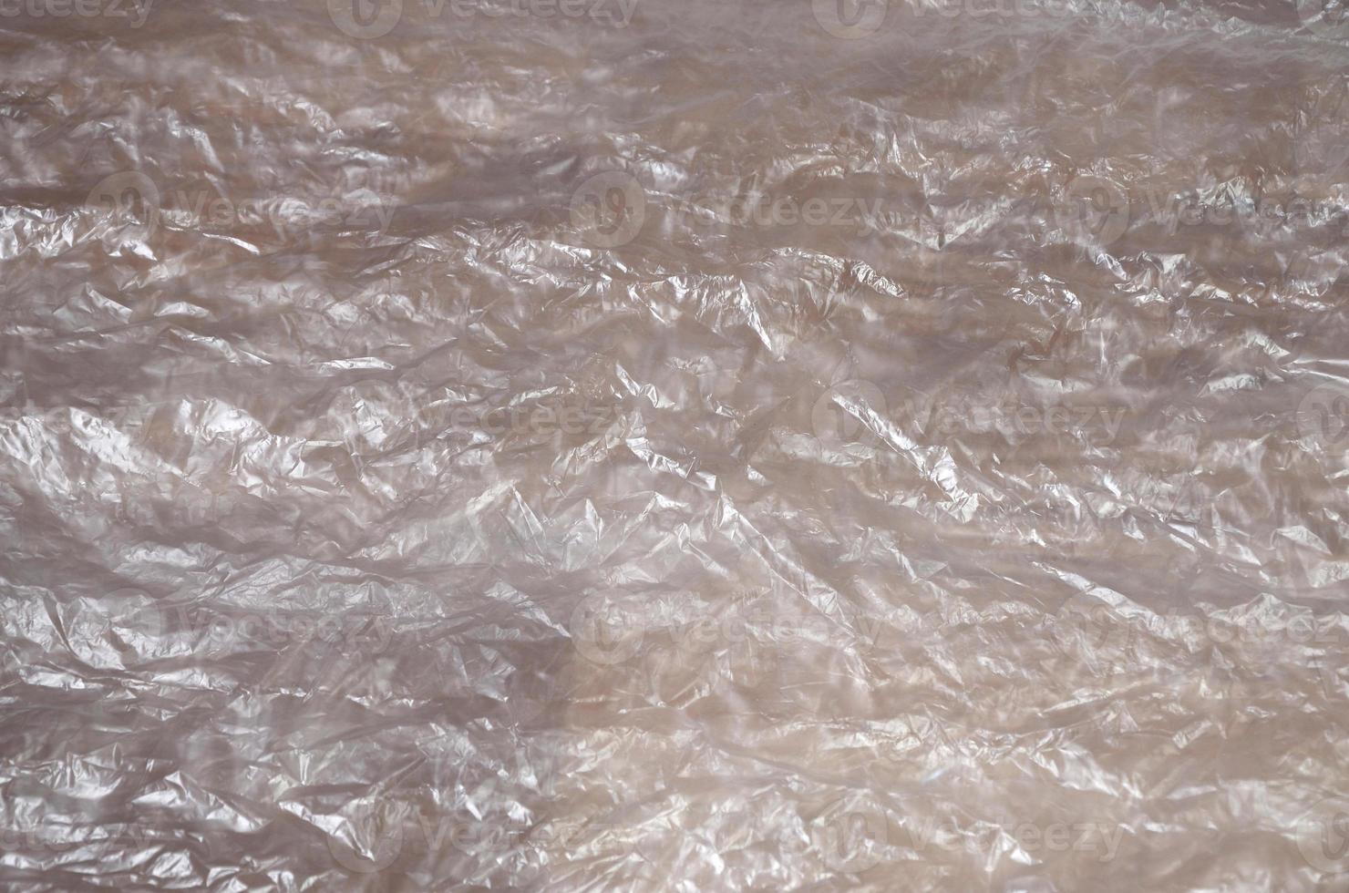 Texture of white crumpled cellophane surface transparent on sunlight. Concept of materials for packaging, product protection against damage photo