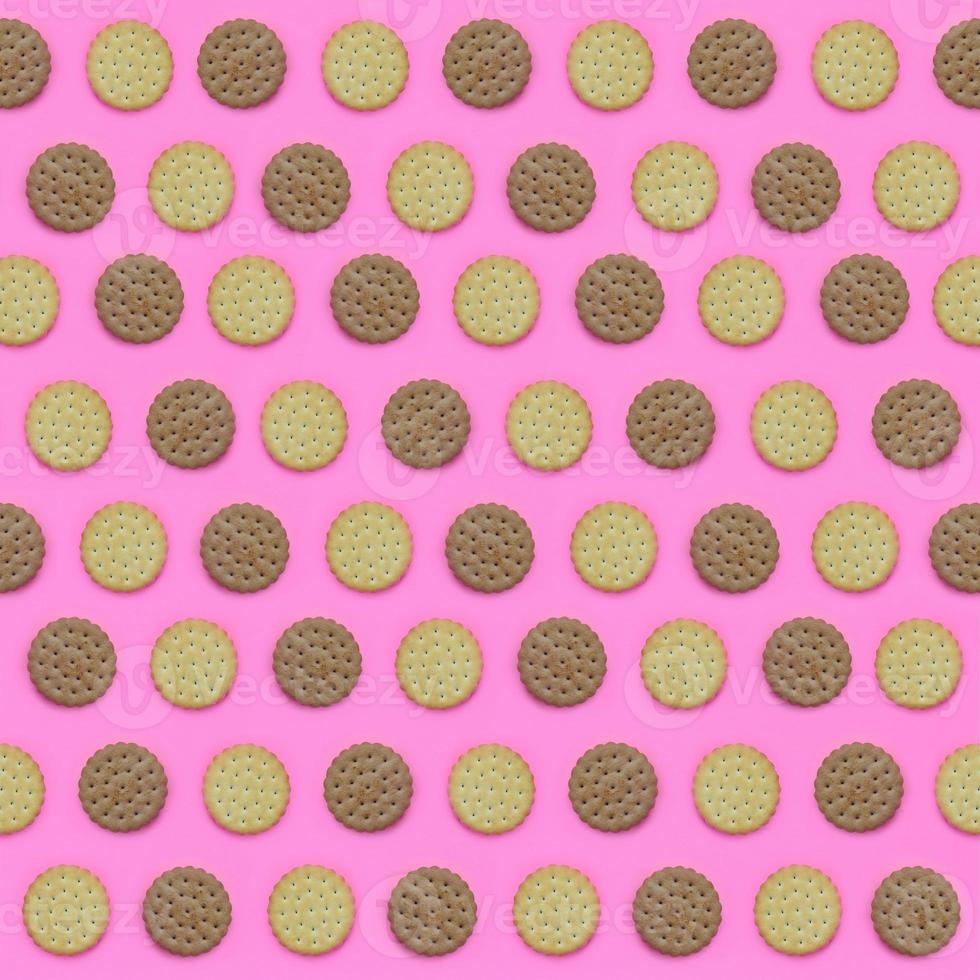 Pattern of a brown biscuits on a pink background. Trendy minimal concept of food and dessert. Abstract flat lay, top view photo