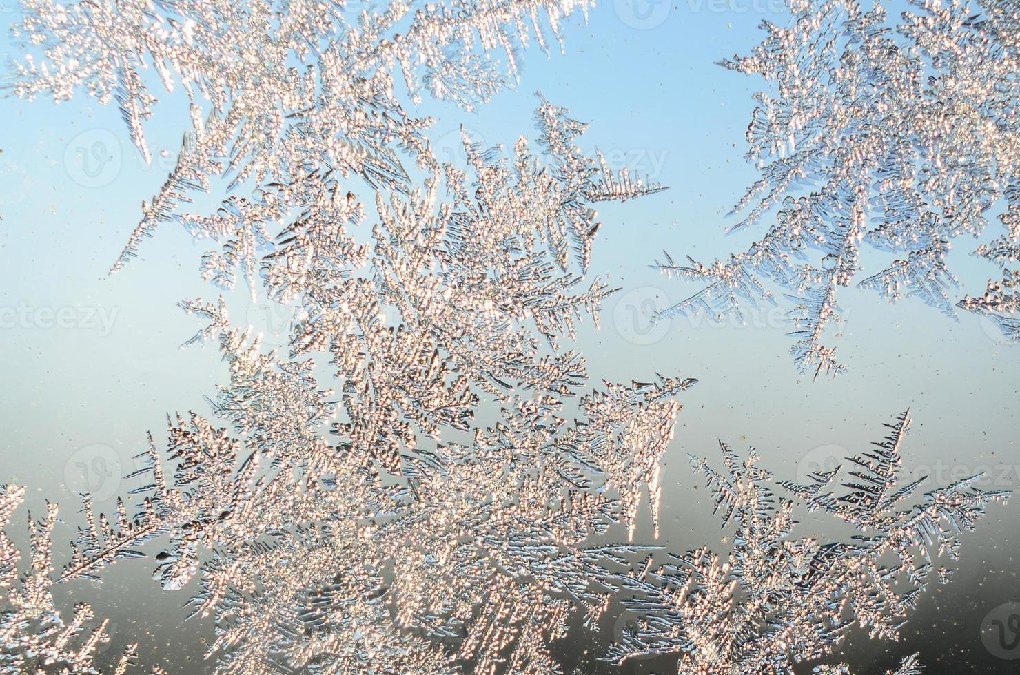 Snowflakes frost rime macro on window glass pane photo