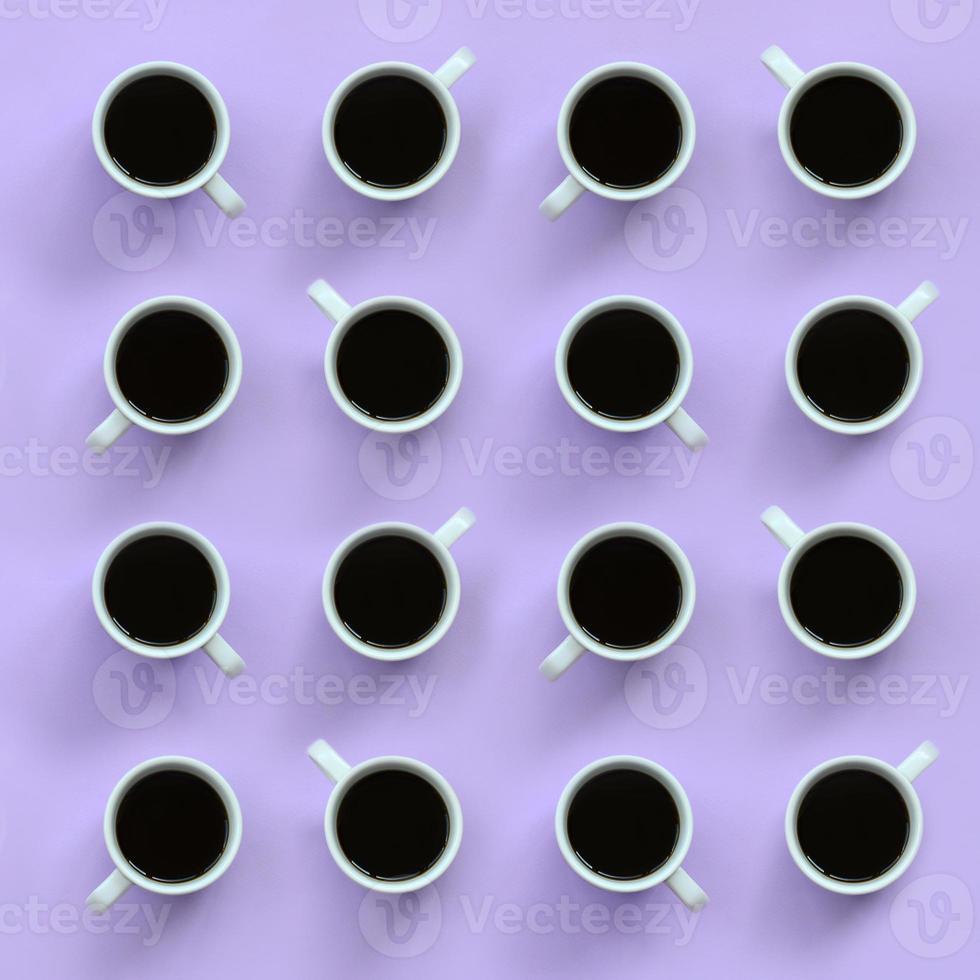 Many small white coffee cups on texture background of fashion pastel violet color paper in minimal concept photo