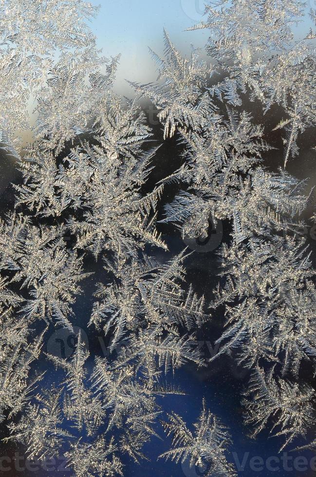 Snowflakes frost rime macro on window glass pane photo