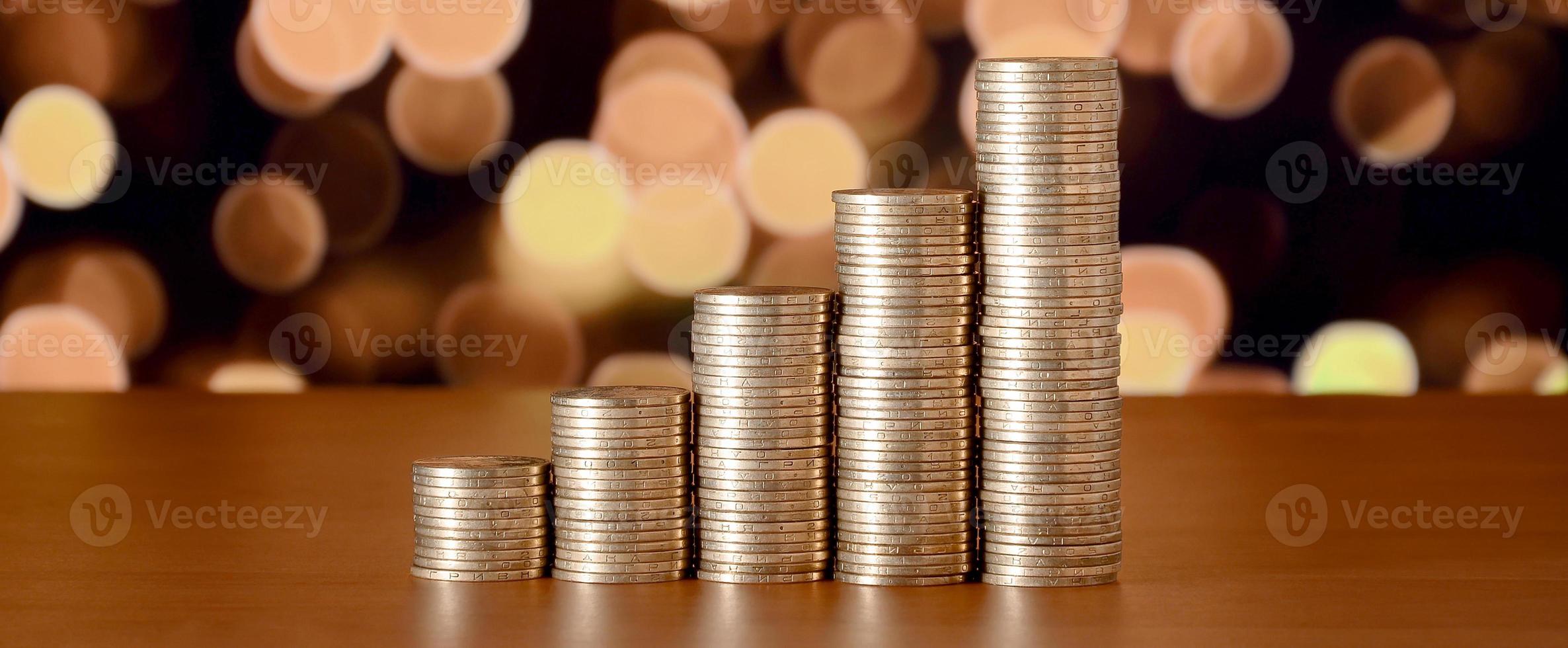 Golden coin stacks arranged as a graph. Increasing columns of coins photo