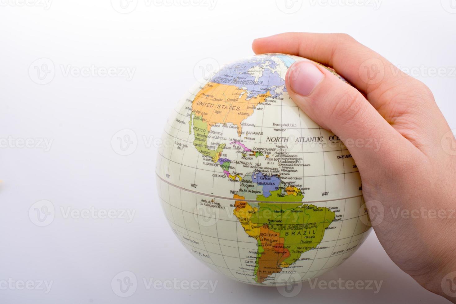 Hand holding a globe  with the map on it photo