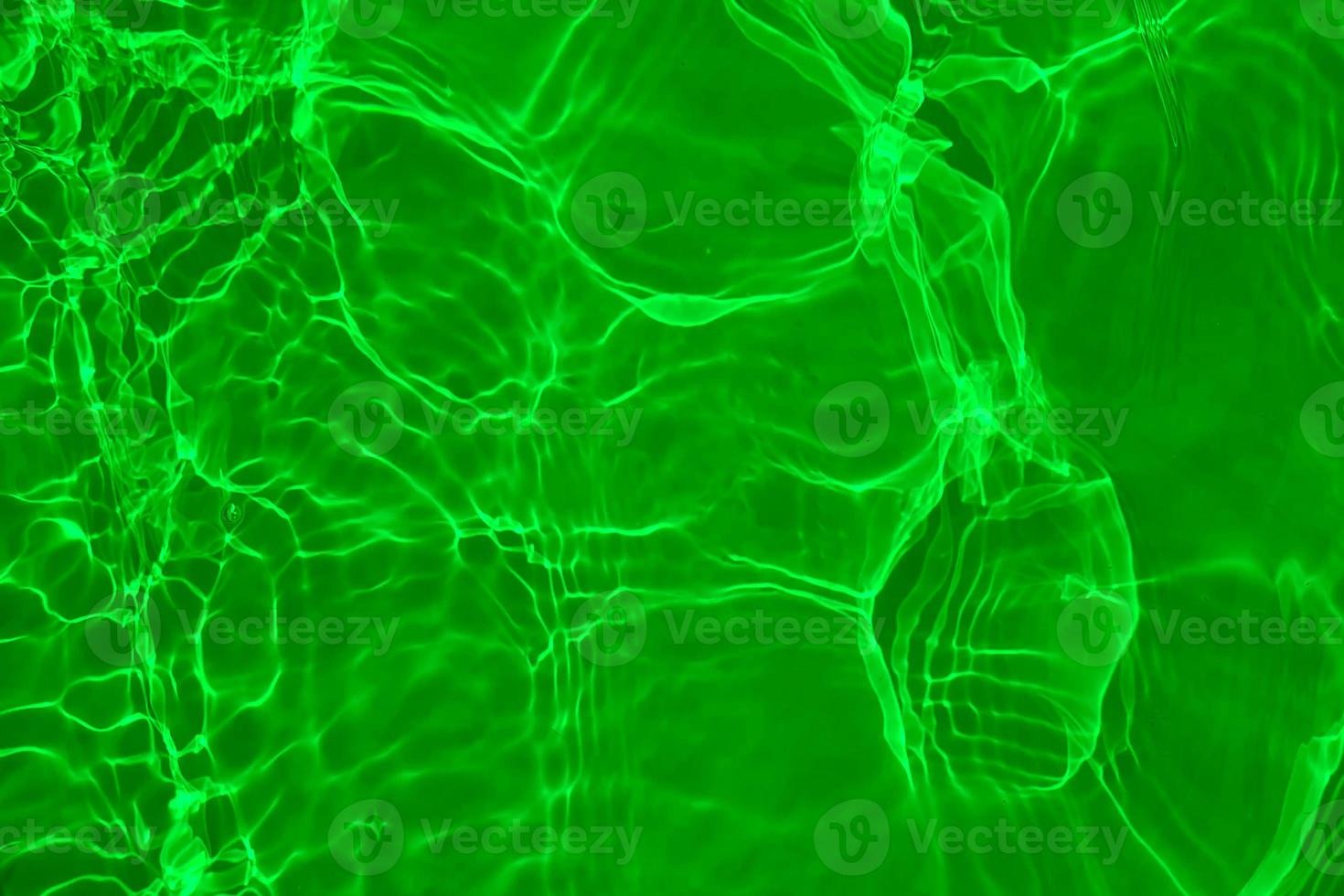 Defocus blurred transparent green colored clear calm water surface texture with splashes and bubbles. Trendy abstract nature background. Water waves in sunlight with copy space. Green watercolor shine photo