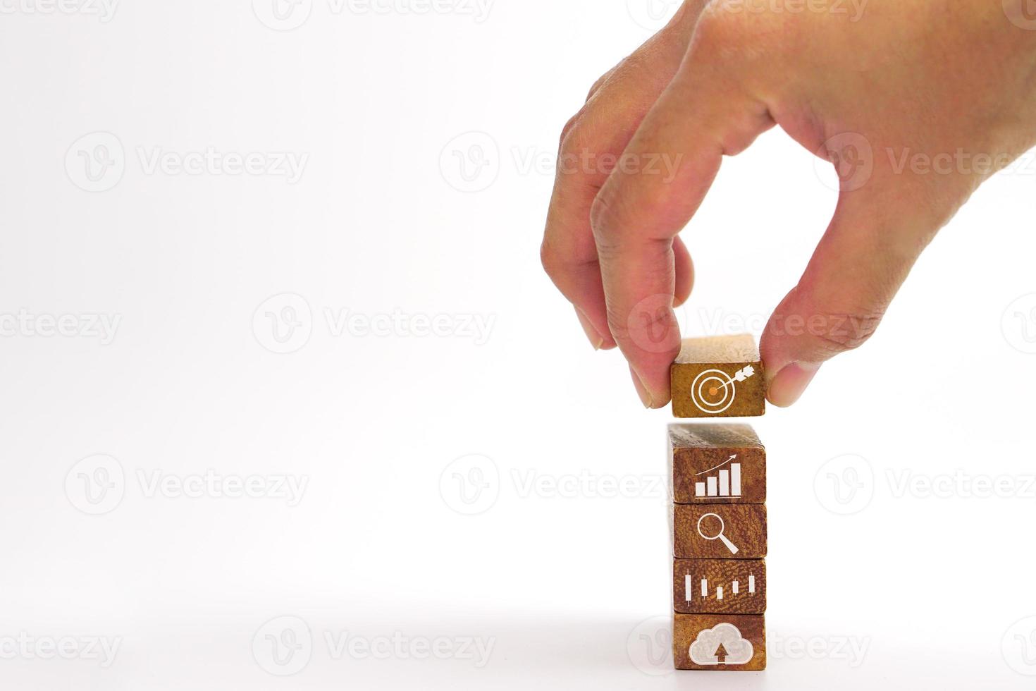 Hand of businessman holding a wooden block with a target icon. Concept of Business success goals and strategy planning to success. photo