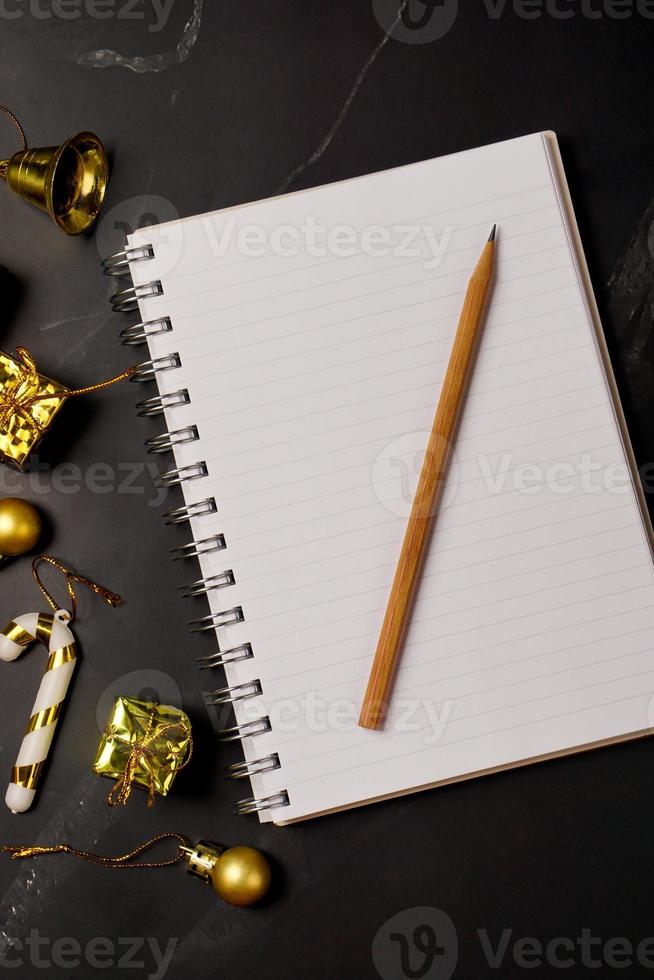 New Year or Christmas of decorations gold and book on black background. Festival, season and greeting card concept. photo