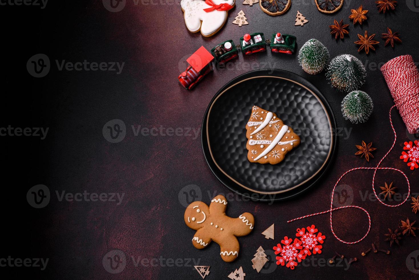 hermosos adornos navideños diferentes y pan de jengibre en una mesa de hormigón marrón foto