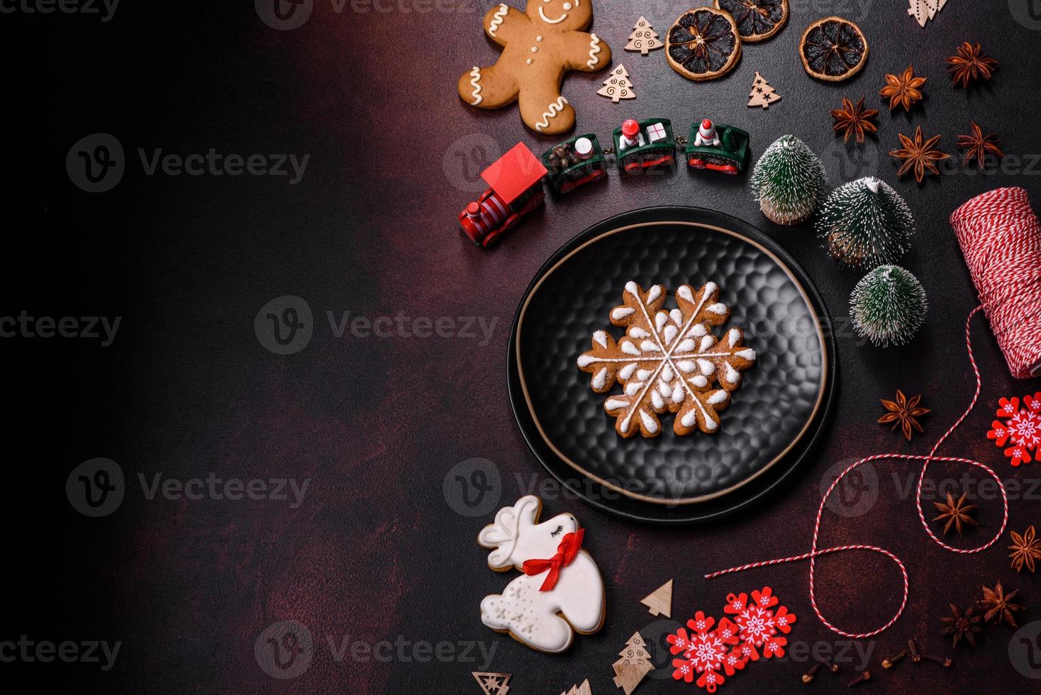 hermosos adornos navideños diferentes y pan de jengibre en una mesa de hormigón marrón foto