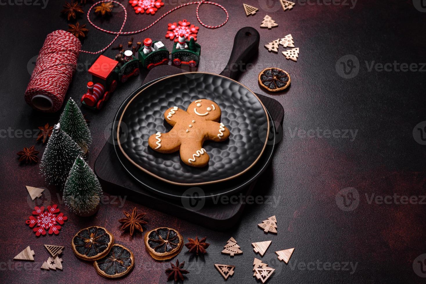 hermosos adornos navideños diferentes y pan de jengibre en una mesa de hormigón marrón foto