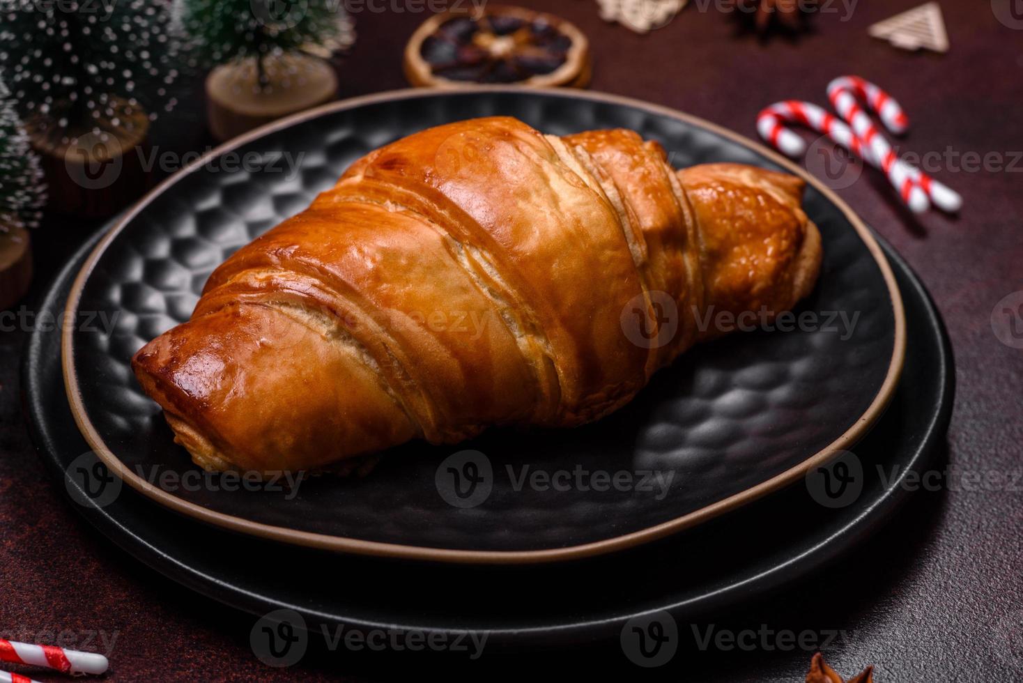 Beautiful different Christmas decorations and croissant on a brown concrete table photo