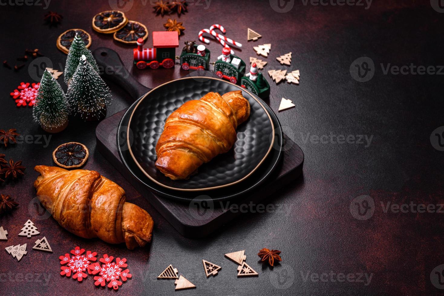 hermosos adornos navideños diferentes y croissant en una mesa de hormigón marrón foto