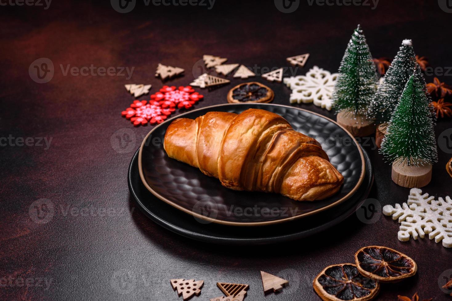 Beautiful different Christmas decorations and croissant on a brown concrete table photo