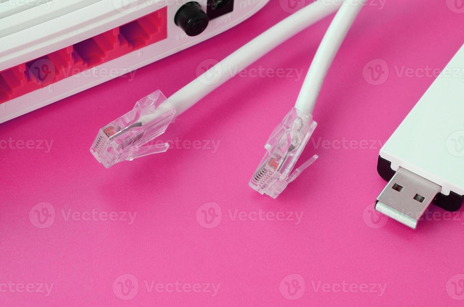 Internet router, portable USB wi-fi adapter and internet cable plugs lie on a bright pink background. Items required for internet photo