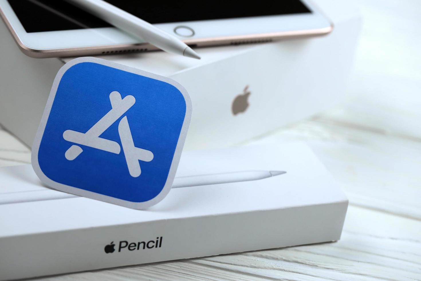 KHARKIV, UKRAINE - JANUARY 27, 2022 Brand new Apple iPad and Apple Pencil and blue app store logo on white background. Apple Inc. is an American technology company photo