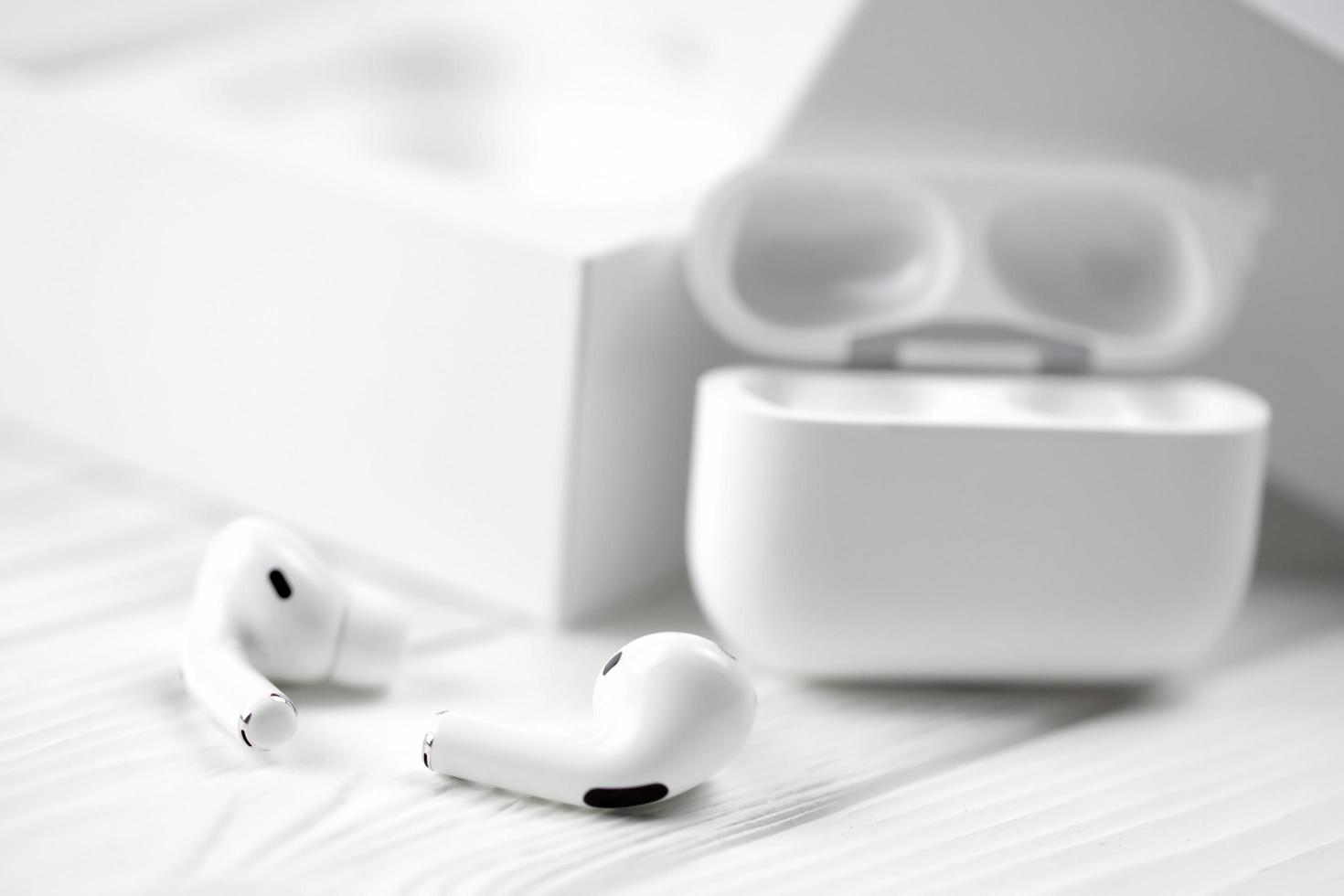 KHARKIV, UKRAINE - JANUARY 27, 2022 Apple AirPods Pro on a white background. Wireless headphones with charging case and a box. Apple Inc. is an American technology company photo