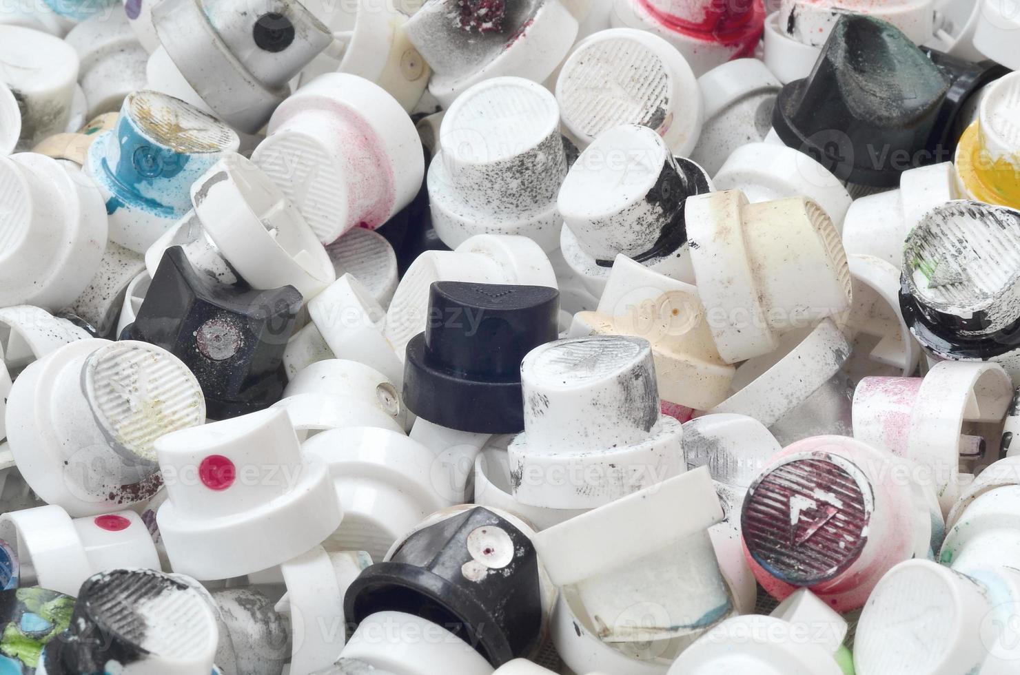 A pattern of many used and soiled nozzles from spray cans with aerosol paint. Background texture of the street art of drawing graffiti on the walls photo