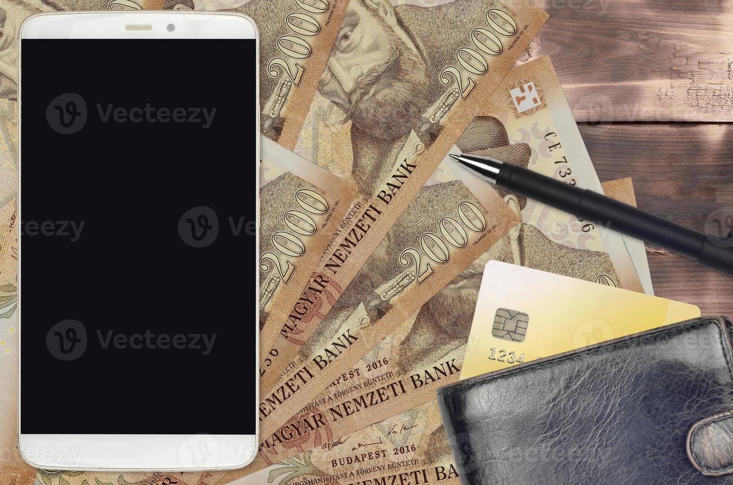 2000 Hungarian forint bills and smartphone with purse and credit card. E-payments or e-commerce concept. Online shopping and business with portable devices photo