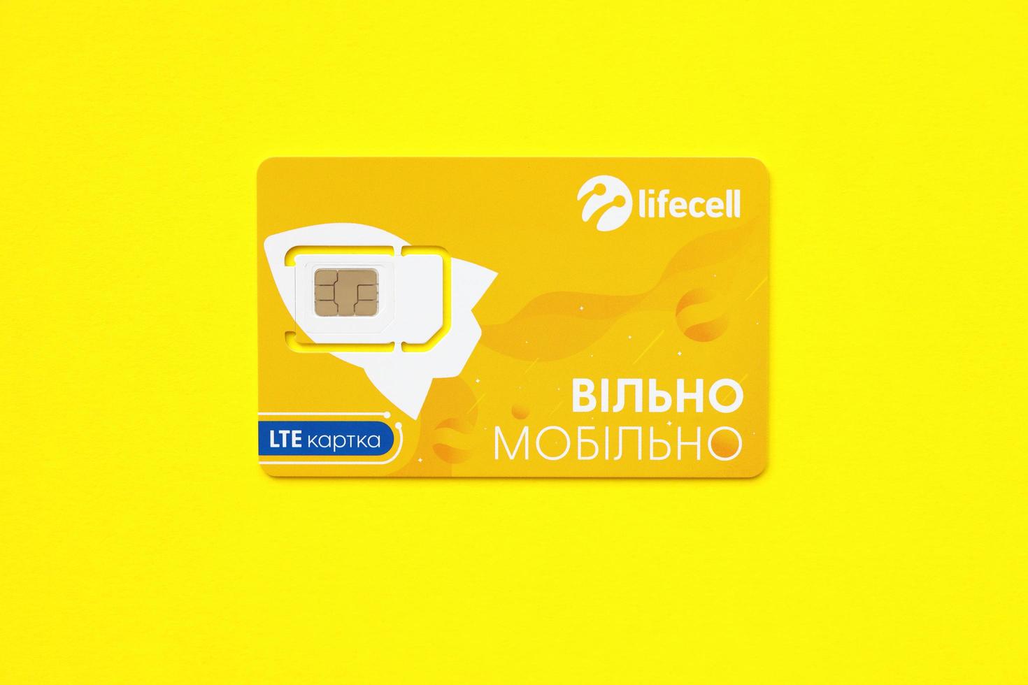 TERNOPIL, UKRAINE - JULY 5, 2022 Lifecell new sim card with free contract on yellow background. Lifecell is ukrainian mobile telephone network operator and provider of wireless connection photo
